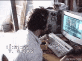 a man wearing headphones is sitting at a desk with a keyboard and a computer monitor with the time of 11:51 on it