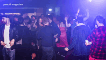 a crowd of people are dancing in a dark room with the words peep magazine visible