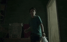 a young boy is running in a dark room holding a bag