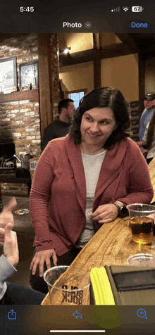 a woman is sitting at a bar with a cup that says ' beer rock ' on it