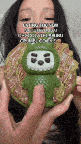 a woman is holding a donut that has a monster on it