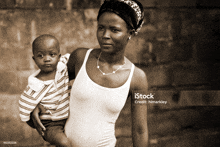 a black and white photo of a woman holding a child with istock written on the bottom