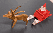 an origami reindeer is next to an origami santa