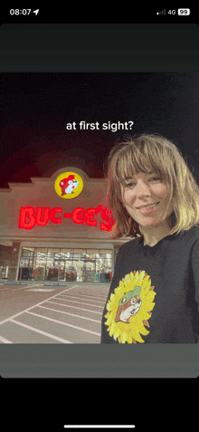 a woman is standing in front of a buck 's store