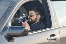 a man is smoking a cigarette in a car