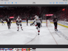 a hockey game is being watched on a tablet with a lenovo ad in the background