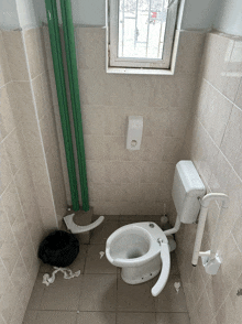 a bathroom with a toilet and a trash can