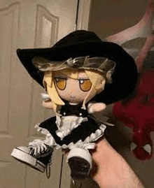 a person is holding a stuffed doll wearing a witch hat .