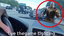 a person driving a car with the words live the game sighting written on the dashboard