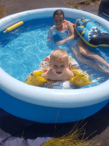 two children are playing in an inflatable pool and one of them is wearing a paw patrol float