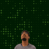a man stands in front of a green background with the number 20 in yellow