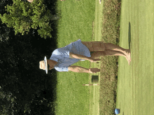 a man in a hat stands on a golf course