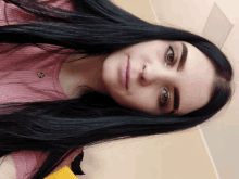 a close up of a woman 's face with a pink shirt on