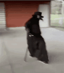 a man in a black coat and top hat is walking down the street