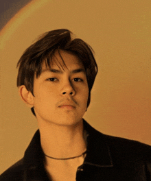 a close up of a young man 's face with a rainbow in the background