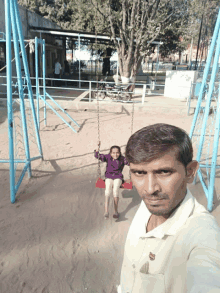 a man taking a selfie with a girl on a swing