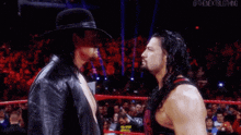 the undertaker and roman reigns are facing each other in the ring .