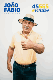 a man wearing a yellow shirt and a straw hat giving a thumbs up