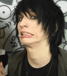 a young man with a nose ring making a face with his tongue out