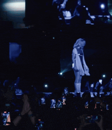 a woman in a white dress is dancing on a stage