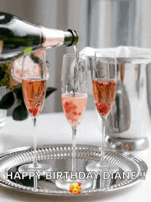 a bottle of champagne is being poured into three champagne flutes with the words happy birthday diane written on the bottom