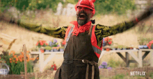 a man with his arms outstretched is wearing an apron and a hard hat with netflix written on the bottom