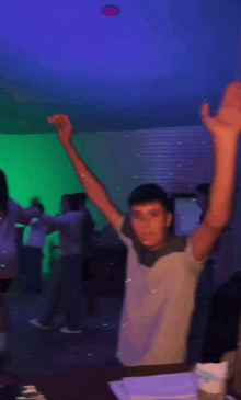 a man with his arms in the air is dancing in a dark room
