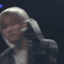 a close up of a person holding a microphone in front of their ear