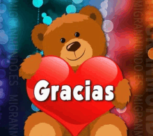 a teddy bear holding a red heart with the word gracias written on it