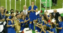 a group of soccer players celebrate with a man holding a trophy in front of a sign that says fifa tv