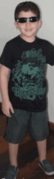 a boy wearing sunglasses and a shirt that says hard rock