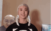 a woman with aluminum foil on her hair is smiling in front of a bald man