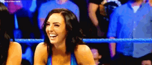 a woman is laughing in a wrestling ring while another woman watches .