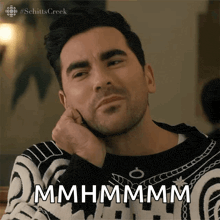 a man in a black and white sweater says mhmhmmm
