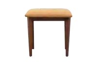 a small wooden stool with an orange cushion on top