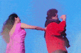 a man in a red jacket and a woman in a pink dress are dancing