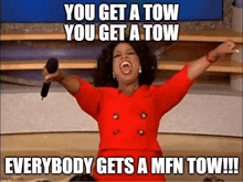 oprah winfrey is holding a microphone with her arms in the air while screaming .