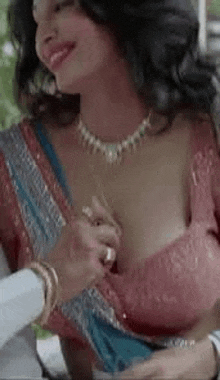 a woman in a saree is being touched by a man in a white shirt .