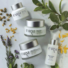 three bottles of farm x cosmetics are surrounded by flowers and leaves