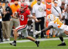 a football player with the number 13 on his jersey is running with the ball .