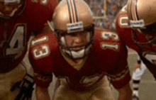 a group of football players are standing in a huddle on the field .