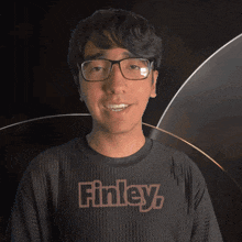 a man wearing glasses and a black shirt that says finley