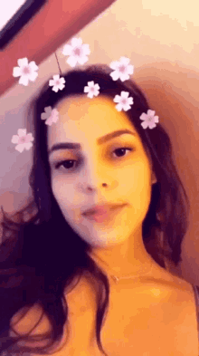 a woman with flowers in her hair is looking at the camera