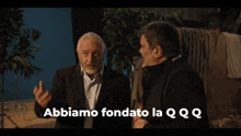 two men standing next to each other with the words abbiamo fondo la qqq written on the bottom