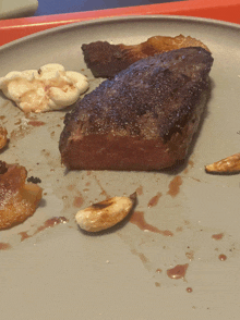 a close up of a plate of food with a piece of steak on it