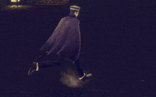 a man in a black cape and hat is walking in the dark
