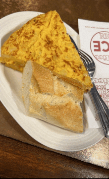 a white plate with a slice of tortilla on a piece of bread