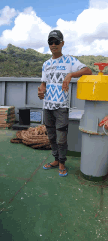 a man wearing a shirt that says " never suck " giving a thumbs up