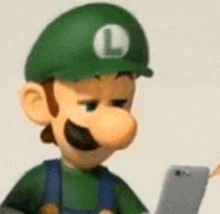 a cartoon character wearing a green hat with the letter l on it is looking at a cell phone .