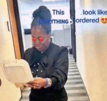 a woman with heart shaped eyes is holding a styrofoam container with a sign that says " this look like everything ordered "
